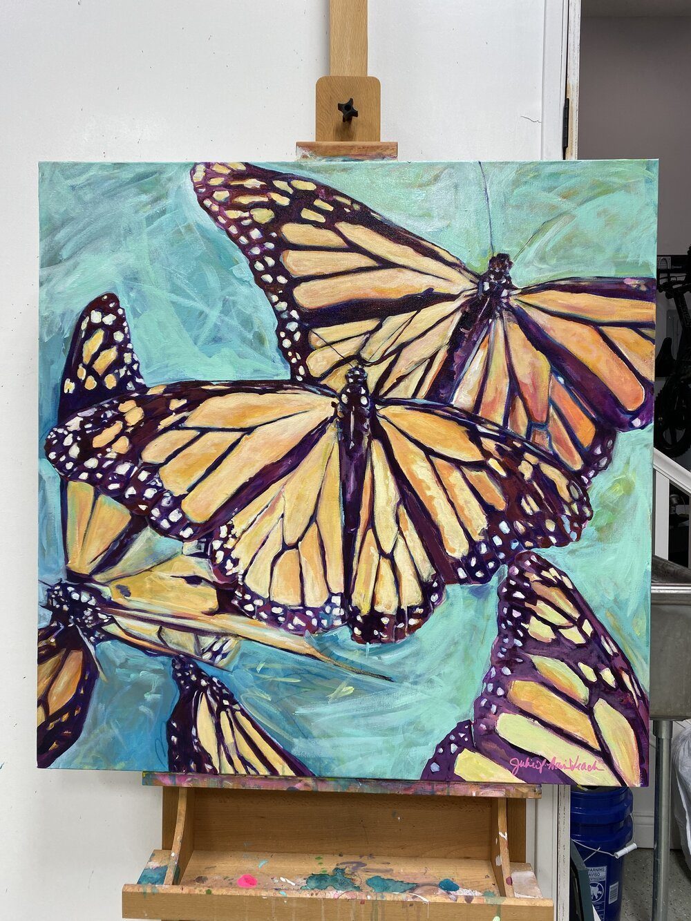 “Transformation Taking Flight” original painting on large canvas by Julie Davis pictured on an easle in her studio
