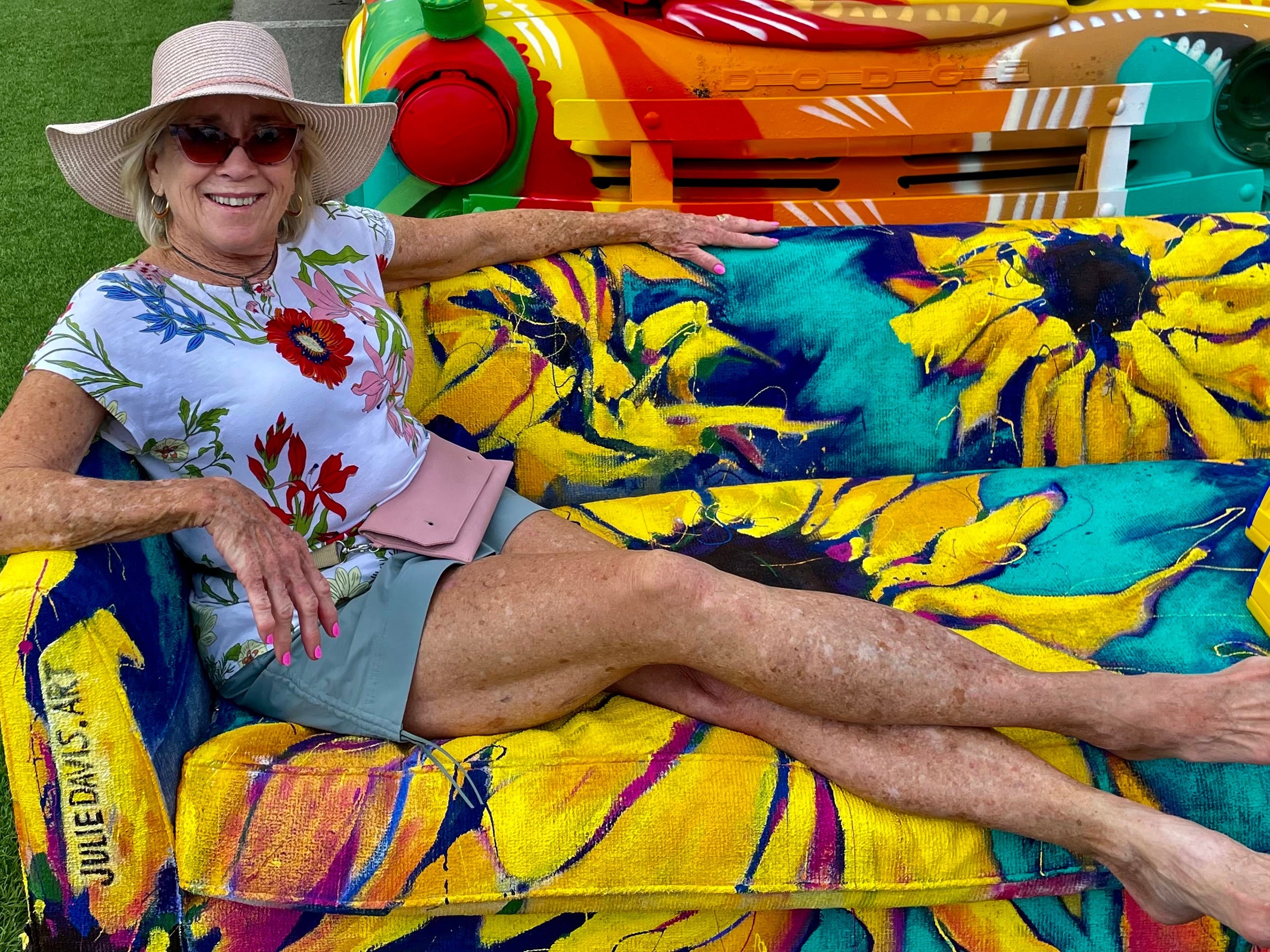 Fair-goer relaxing on the Sunflower Sofa by Julie Davis part of the Big Art - art activation debuting at  the 2022 Indiana State Fair 